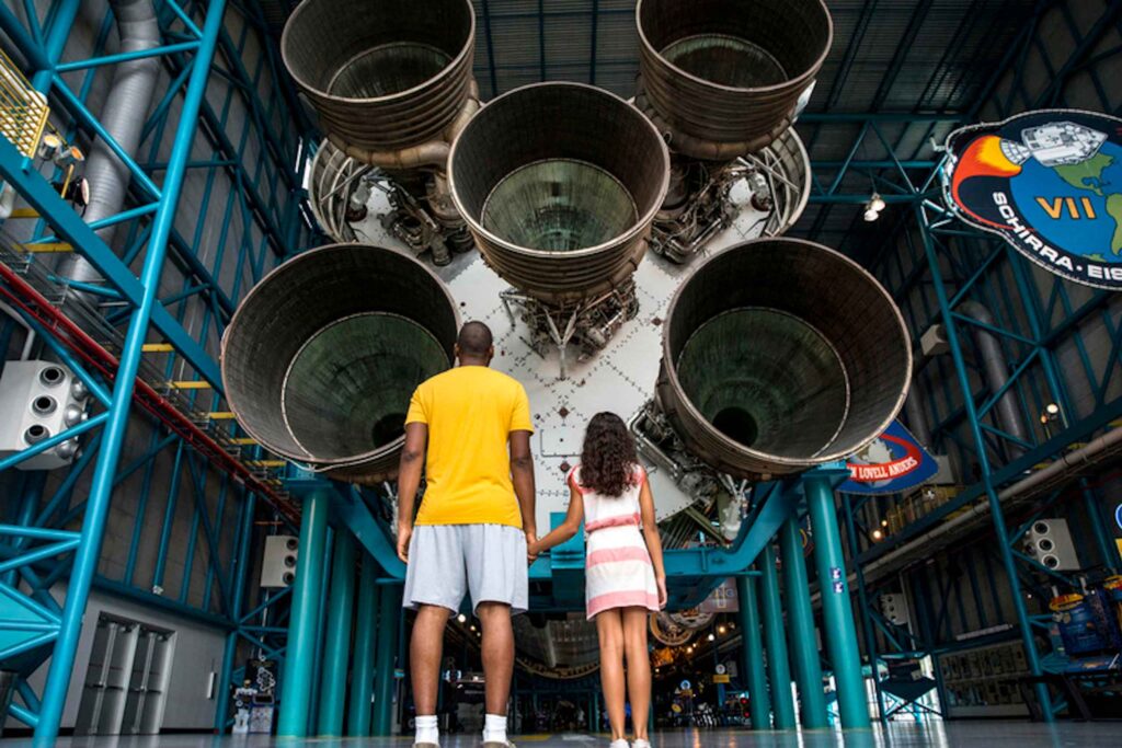 people looking up at space exhibit