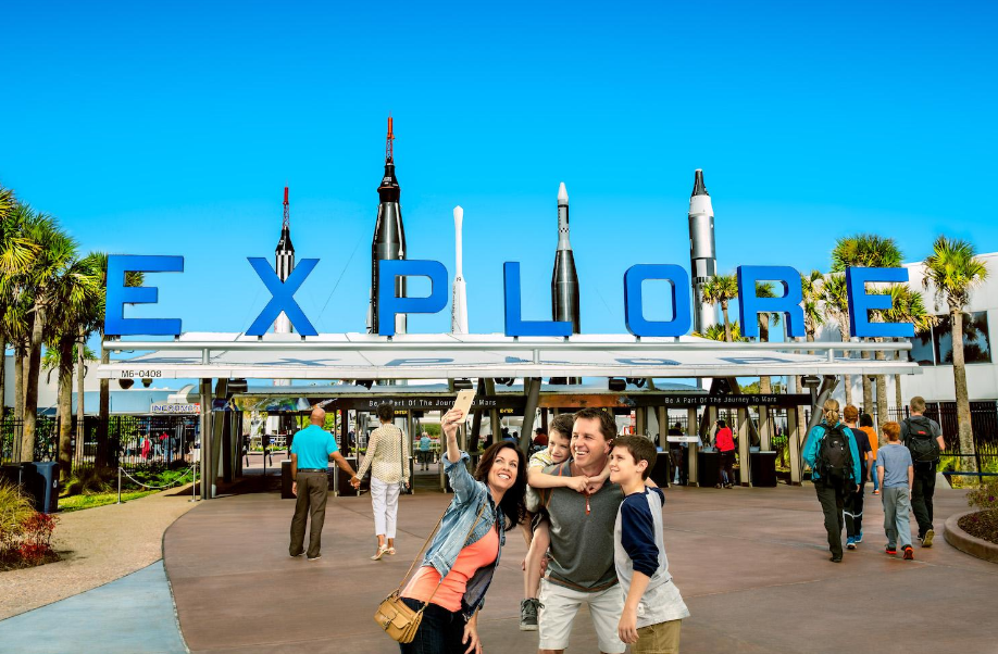 Family infront of Explore sign with rockets