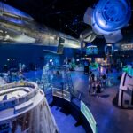 gateway building of exhibits at the kennedy space center featuring the drag starliner simulator with blue lights